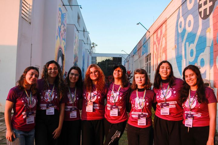 equipe de organização da MFP 2025 em frente aos murais do campus